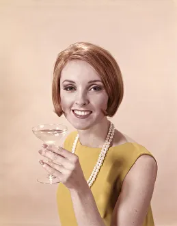 Portrait of glamorous woman in pearls holding cocktail Portrait of glamorous woman in pearls holding cocktail