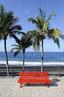 Red park bench on the beach promenade of Puerto Naos, La Palma, Canary Islands, Canary Islands, Spain, Europe Red park bench on the beach promenade of Puerto Naos, La Palma, Canary Islands, Canary Islands, Spain, Europe