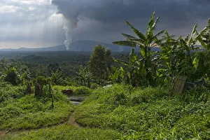 Rural dwelling with erupting Nyamuragira Volcano in background, Virunga National Park Rural dwelling with erupting Nyamuragira Volcano in background, Virunga National Park