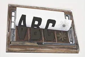 Sheet of paper peeling away from a printing forme imprinted with the letters ABC and image of a flower Sheet of paper peeling away from a printing forme imprinted with the letters ABC and image of a flower