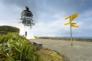 Signpost with distances and lighthouse at Cape Reinga, Cape Reinga, Northland Region, New Zealand Signpost with distances and lighthouse at Cape Reinga, Cape Reinga, Northland Region, New Zealand