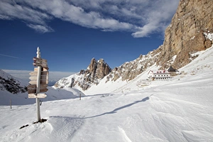 Signpost, Tierser Alplhutte mountain cabin and Rosszahne peaks in winter, Seiser Alm alp, Province of South Tyrol Signpost, Tierser Alplhutte mountain cabin and Rosszahne peaks in winter, Seiser Alm alp, Province of South Tyrol