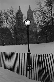 Small wooden fence and a lamppost in a snowy park Small wooden fence and a lamppost in a snowy park
