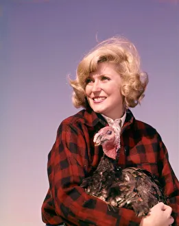 Smiling blonde woman holding thanksgiving turkey Smiling blonde woman holding thanksgiving turkey
