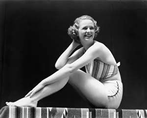 Smiling Blonde Woman Wearing 2 Piece Bathing Suit Striped Halter Top Sitting Full Figure Smiling Blonde Woman Wearing 2 Piece Bathing Suit Striped Halter Top Sitting Full Figure