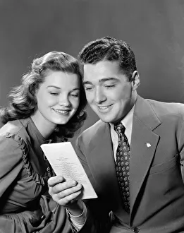 Smiling couple looking at insurance policy brochure Smiling couple looking at insurance policy brochure