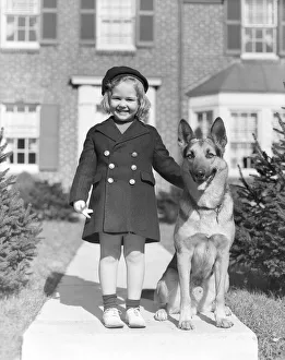 Smiling Girl With A German Shepherd Wearing A Tam & Brass 6 Button Navy Overcoat With Smiling Girl With A German Shepherd Wearing A Tam & Brass 6 Button Navy Overcoat With