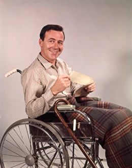 Smiling man in wheelchair, holding insurance check Smiling man in wheelchair, holding insurance check