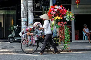 A street vendor with a bicycle selling her flowers in Hanoi, Vietnam, Asia A street vendor with a bicycle selling her flowers in Hanoi, Vietnam, Asia