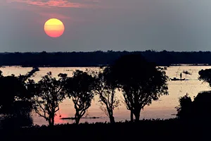the Sun coming down over tonle sap lake and Fisherman fishing on the boat the Sun coming down over tonle sap lake and Fisherman fishing on the boat