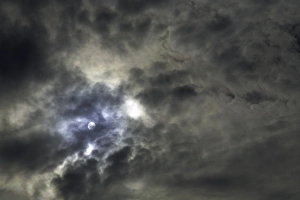 Sun behind layer of cloud, low angle view Sun behind layer of cloud, low angle view
