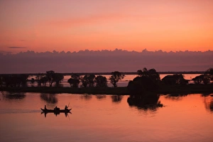 Sunrise sky over tonle sap lake and Fisherman fishing on the boat Sunrise sky over tonle sap lake and Fisherman fishing on the boat