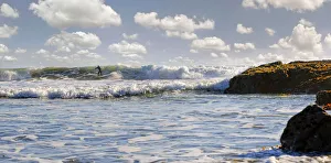 Surfer in the surf on the Pacific beach near Cambria, California, United States Surfer in the surf on the Pacific beach near Cambria, California, United States