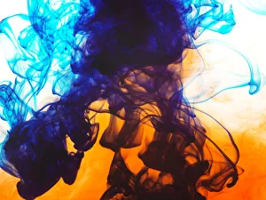 Swirls of spreading orange and blue ink in liquid Swirls of spreading orange and blue ink in liquid