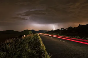 A thunderstorm at night with lightning on a remote road in the Cradle of Humankind A thunderstorm at night with lightning on a remote road in the Cradle of Humankind