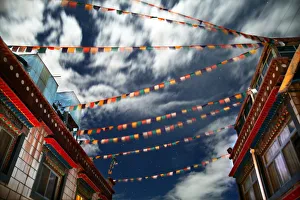Tibetan prayer flags fly in night sky over house Tibetan prayer flags fly in night sky over house