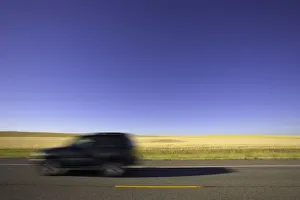USA, Montana, SUV on highway beside wheatfield (blurred motion) USA, Montana, SUV on highway beside wheatfield (blurred motion)