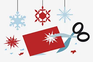 Using scissors to cut out snowflake shapes for Christmas decorations Using scissors to cut out snowflake shapes for Christmas decorations