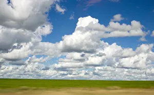 View of Cumulus Clouds Spread Over Green Fields View of Cumulus Clouds Spread Over Green Fields