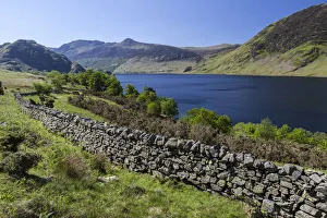 View over an old English stone wall towards the blue lake of Crummock Water, Lake District National Park, Cumbria View over an old English stone wall towards the blue lake of Crummock Water, Lake District National Park, Cumbria