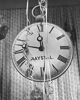 Wall clock covered in party streamers, (B&W) Wall clock covered in party streamers, (B&W)