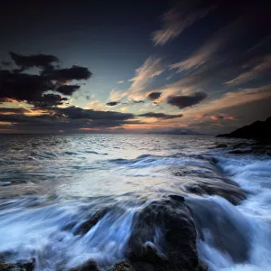 Water flowing over rocks on sea at sunset Water flowing over rocks on sea at sunset