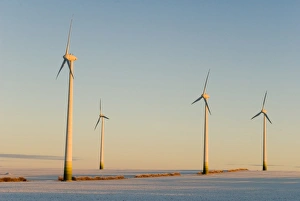 Wind turbines in winter at sunrise on a snowy field, Saxony-Anhalt, Germany, Europe Wind turbines in winter at sunrise on a snowy field, Saxony-Anhalt, Germany, Europe