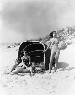 Three Women On Beach Two Are Under Canvas Sun Wind Screen With Fringe Other Is Standing Three Women On Beach Two Are Under Canvas Sun Wind Screen With Fringe Other Is Standing