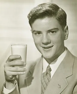 Young man holding glass of milk, (B&W), portrait Young man holding glass of milk, (B&W), portrait