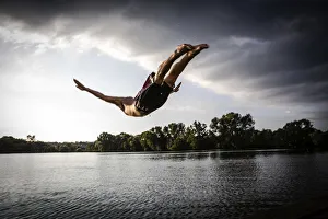 A young man plunging into water from the riverside, Germany A young man plunging into water from the riverside, Germany