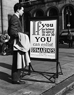 Young man reading US Marines recruitment post Young man reading US Marines recruitment post