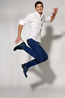 Young man in white shirt and blue jeans jumping Young man in white shirt and blue jeans jumping