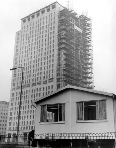 Dwarfed by the new Shell skyscraper is the sun cottage . One of three new portable Dwarfed by the new Shell skyscraper is the sun cottage . One of three new portable