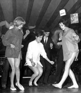These three young ladies are practicing the newest dance craze , The Twist , while These three young ladies are practicing the newest dance craze , The Twist , while