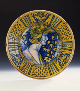 A Deruta lustred portrait dish painted in blue and lustred in yellow depicting a warrior A Deruta lustred portrait dish painted in blue and lustred in yellow depicting a warrior