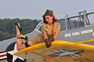 1940s style pin-up girl lying on a T-6 Texan training aircraft 1940s style pin-up girl lying on a T-6 Texan training aircraft
