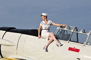 1940s style pin-up girl sitting outside the cockpit of a T-6 Texan 1940s style pin-up girl sitting outside the cockpit of a T-6 Texan