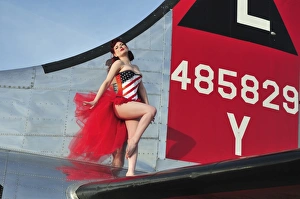 1940s style pin-up girl standing on the tail of a B-17 bomber 1940s style pin-up girl standing on the tail of a B-17 bomber