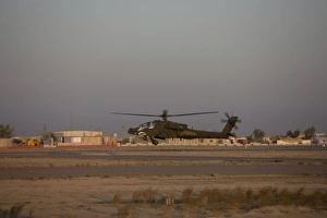 An AH-64D Apache Longbow Block III attack helicopter hovers above the runway An AH-64D Apache Longbow Block III attack helicopter hovers above the runway