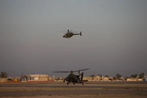 An AH-64D Apache Longbow Block III waits for an OH-58 Kiowa to clear his flight space An AH-64D Apache Longbow Block III waits for an OH-58 Kiowa to clear his flight space