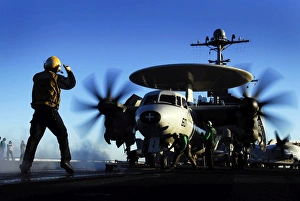 An Airman guides an E-2C Hawkeye An Airman guides an E-2C Hawkeye
