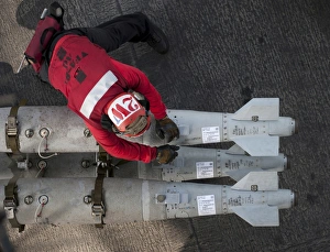 An airman moves ordnance on the flight deck of the aircraft carrier USS Carl Vinson An airman moves ordnance on the flight deck of the aircraft carrier USS Carl Vinson