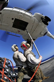 Airmen attach pallet rigs to an SA-330J Puma helicopter aboard USS Essex Airmen attach pallet rigs to an SA-330J Puma helicopter aboard USS Essex