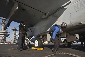 Airmen chain down an F/A-18E Super Hornet Airmen chain down an F/A-18E Super Hornet