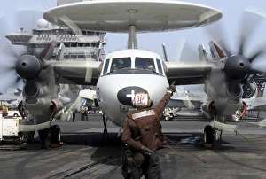 Aviation Electronics Technician directs an E-2C Hawkeye to start its engines Aviation Electronics Technician directs an E-2C Hawkeye to start its engines