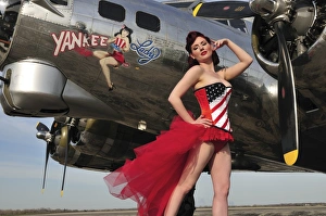 Beautiful 1940s style pin-up girl standing under a B-17 bomber Beautiful 1940s style pin-up girl standing under a B-17 bomber