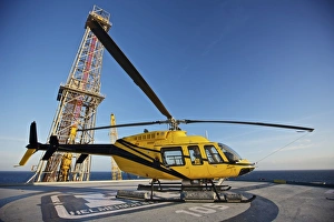 A Bell 407 utility helicopter on the helipad of an oil rig A Bell 407 utility helicopter on the helipad of an oil rig
