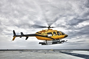 A Bell 407 utility helicopter prepares to land on an oil rig A Bell 407 utility helicopter prepares to land on an oil rig
