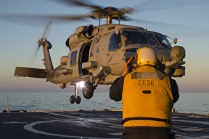 Boatswains Mate guides an MH-60R Sea Hawk onto the flight deck Boatswains Mate guides an MH-60R Sea Hawk onto the flight deck