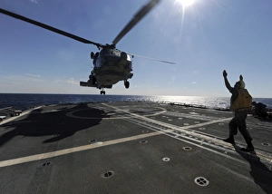 Boatswains Mate signals the pilots of an SH-60B Sea Hawk helicopter Boatswains Mate signals the pilots of an SH-60B Sea Hawk helicopter